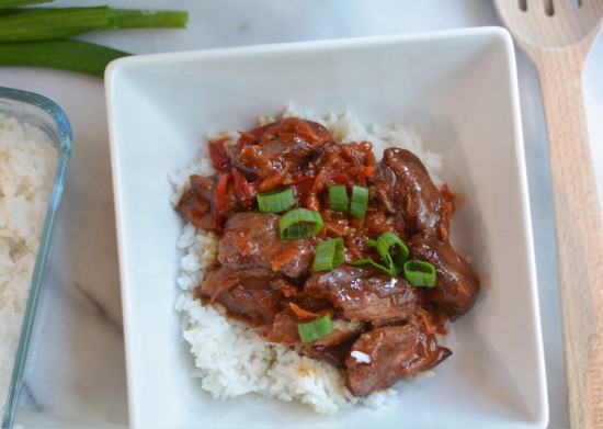 flank steak covered in mongolian sauce on top of rice