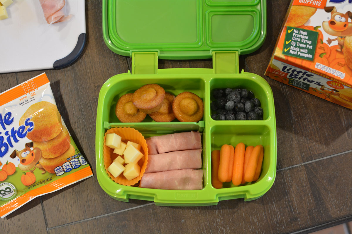 bento lunchbox with pumpkin muffins, cheese, blueberries and carrots