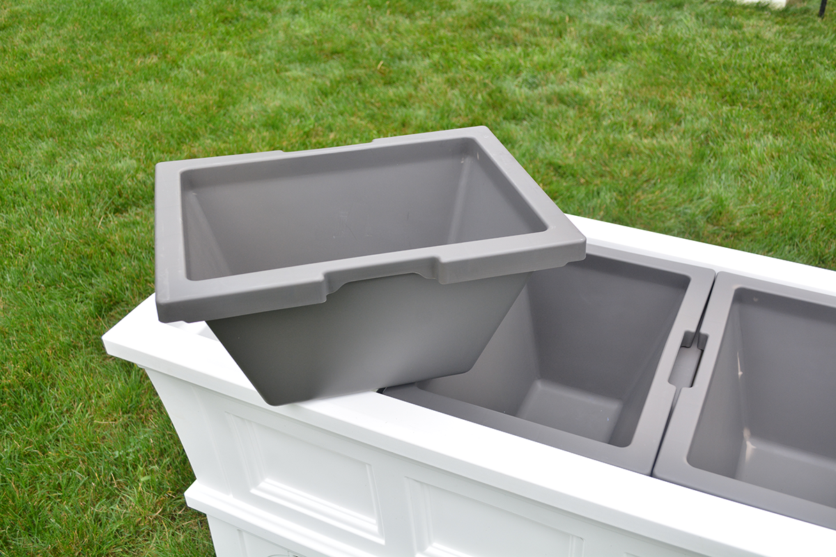 gray bin sitting on top of raised planter box